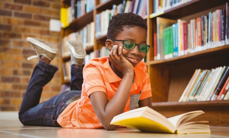 Boy reading a book in a school library